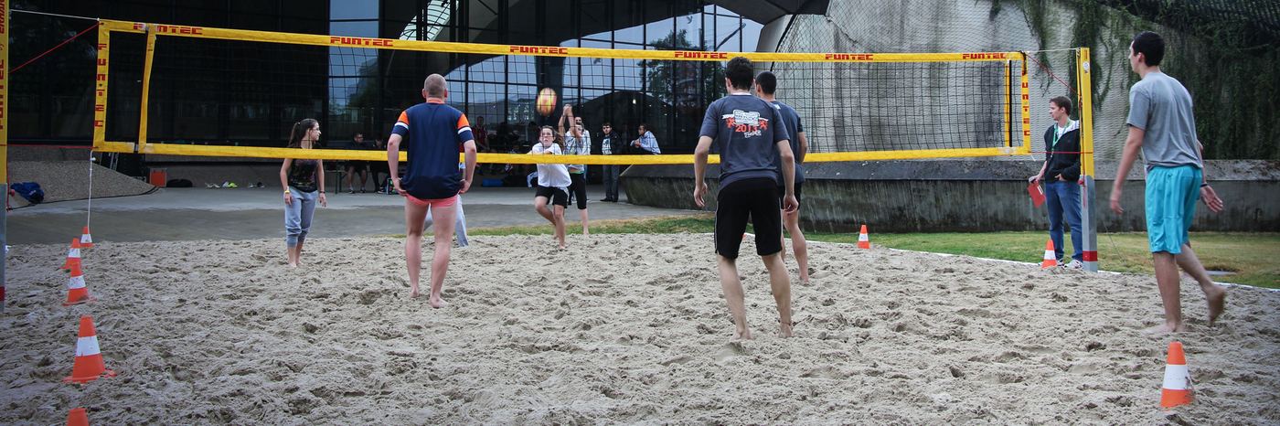 Colleagues playing beach volleyball on a sand court
