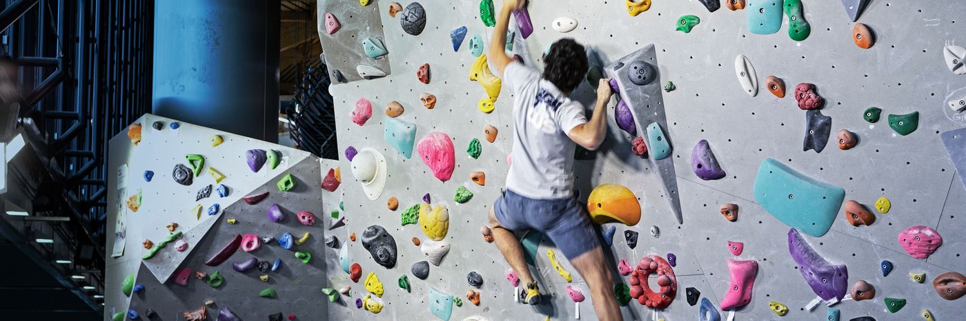 A climber on the colourful bouldering wall
